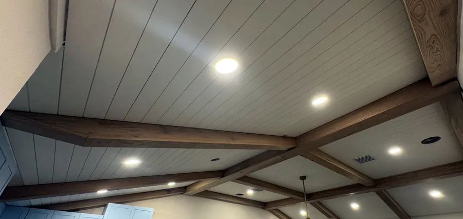 Vaulted shiplap ceiling with wood beams and recessed lights