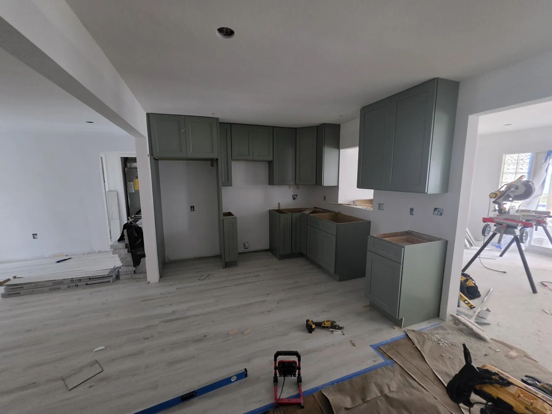 Green shaker kitchen cabinets during installation in a Tampa Bay home